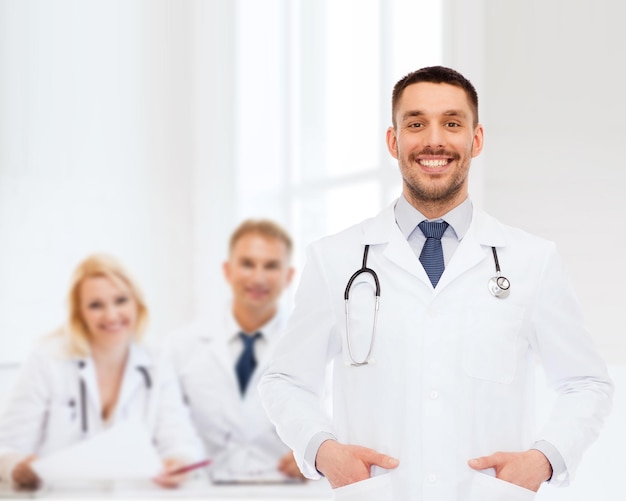 gezondheidszorg, beroep en geneeskunde concept - lachende mannelijke arts met stethoscoop in witte jas op witte achtergrond