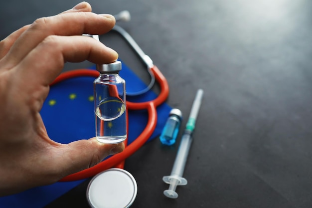 Gezondheidszorg concept EU-vlag en stethoscoop op een grijze achtergrond Vaccinatie en epidemie