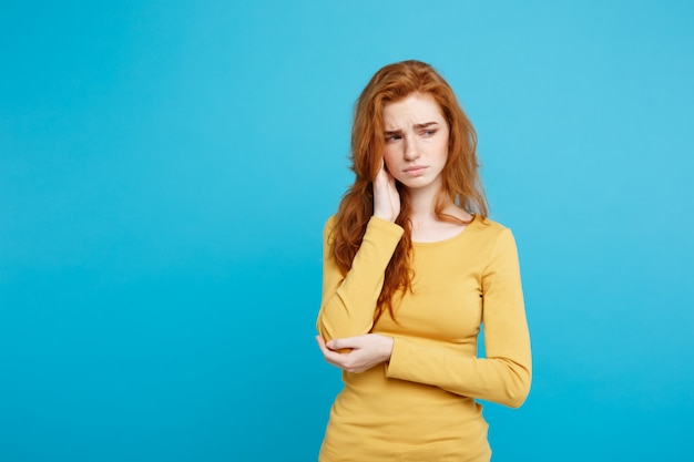 Gezondheidszorg concept - Portret van jonge mooie gember vrouw ziek en stressvol. Geïsoleerd op pastel blauwe achtergrond. Kopieer de ruimte.