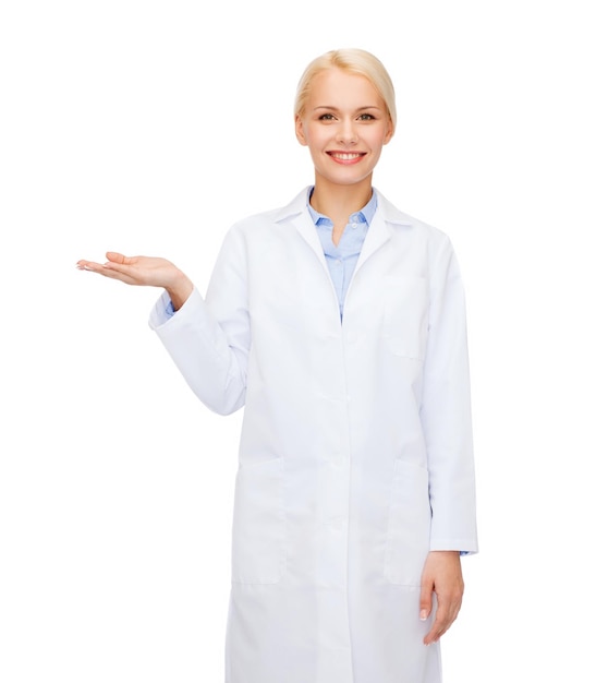 gezondheidszorg en geneeskundeconcept - glimlachende vrouwelijke arts die iets op palm van haar hand houdt