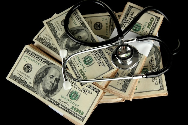 Gezondheidszorg kosten concept stethoscoop en dollars geïsoleerd op zwart