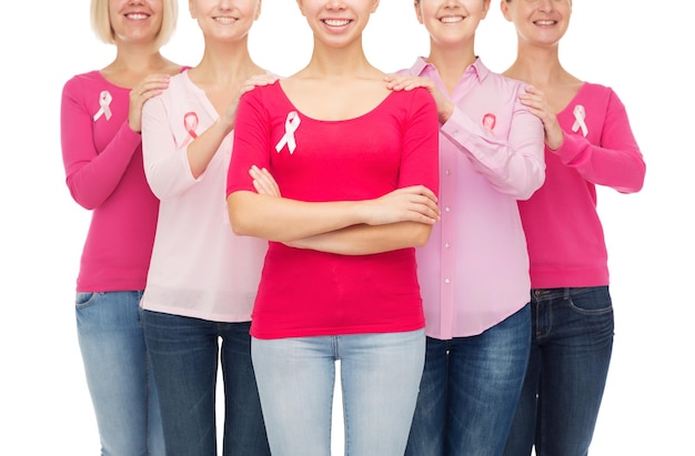 gezondheidszorg, mensen en geneeskunde concept - close-up van lachende vrouwen in lege shirts met roze borstkanker bewustzijn linten op witte achtergrond