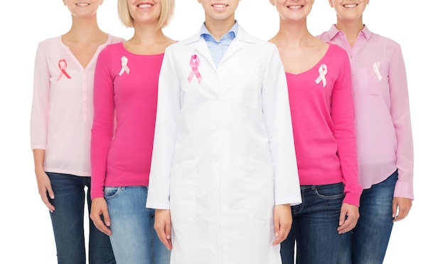 gezondheidszorg, mensen en geneeskunde concept - close-up van lachende vrouwen in lege shirts met roze borstkanker bewustzijn linten op witte achtergrond