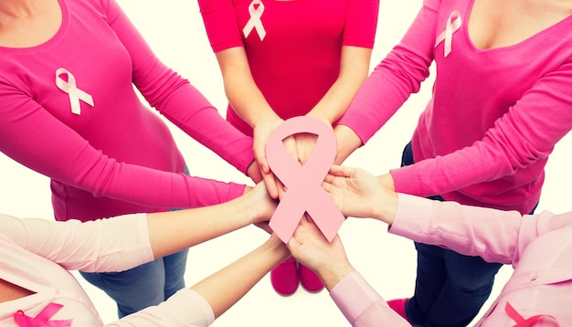 Foto gezondheidszorg, mensen en geneeskunde concept - close-up van vrouwen in lege shirts met roze borstkanker bewustzijn linten op witte achtergrond