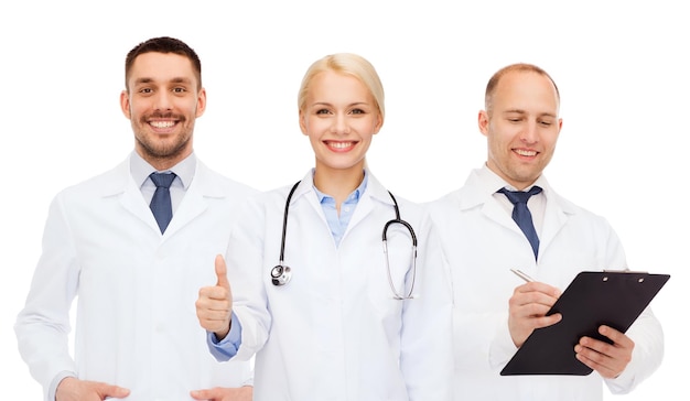 gezondheidszorg, mensen, gebaar en geneeskundeconcept - groep artsen met stethoscoop en klembord die duimen op witte achtergrond tonen