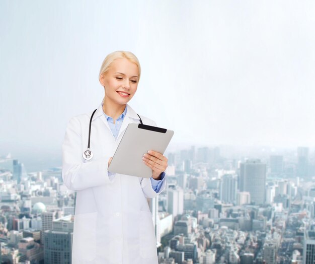 gezondheidszorg, technologie en geneeskunde concept - glimlachende vrouwelijke arts met stethoscoop en tablet pc-computer