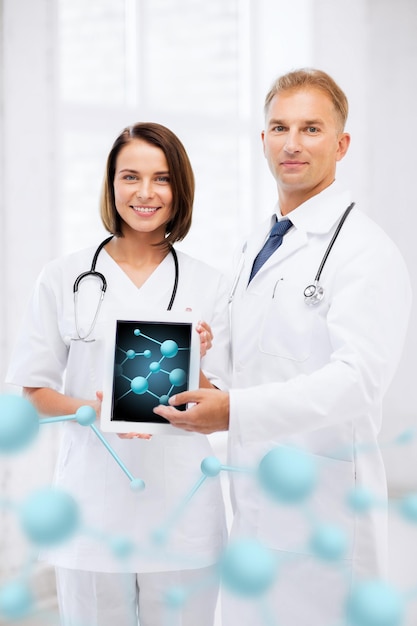 Gezondheidszorg, ziekenhuis, onderzoek, wetenschap en medisch concept - twee artsen die tablet-pc met moleculen tonen