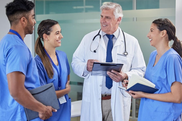 Gezondheidszorgtablet of arts met verpleegkundigen in het ziekenhuis voor chirurgieplanning of leerondersteuning Kliniek teamwerk of volwassen mentorchirurg met stagiairgroep voor digitale checklist of onderwijs