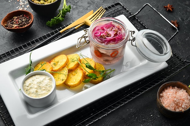 Gezouten haring met uien en gebakken aardappelen Koude snacks In een wit bord Bovenaanzicht