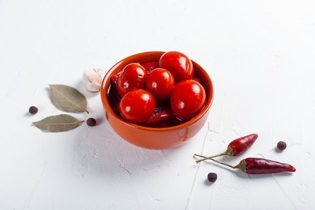 Gezouten rode tomaten met ingrediënten op een witte tafel