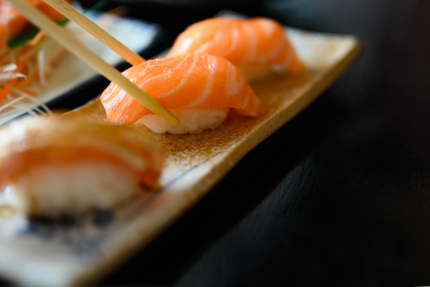 Gezouten sushi met stokjes in een sushiwinkel. Zalmsushi.