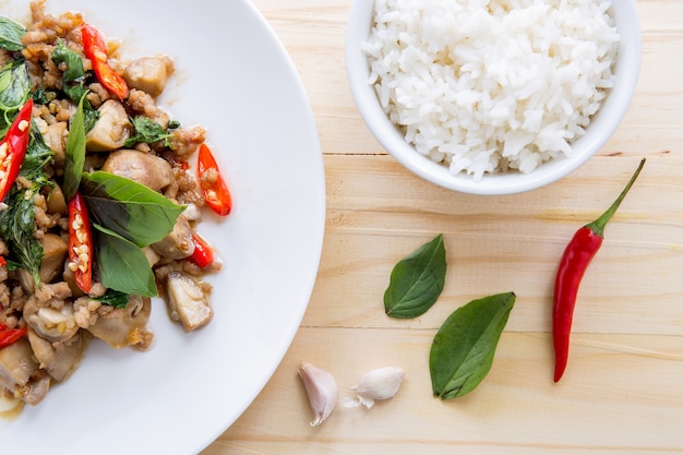 Gezouten varkensvlees met chili, basilicumbladeren en rijst op tafel