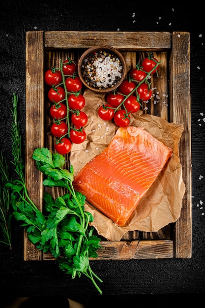 Gezouten zalm met peterselie en tomaten op een houten dienblad