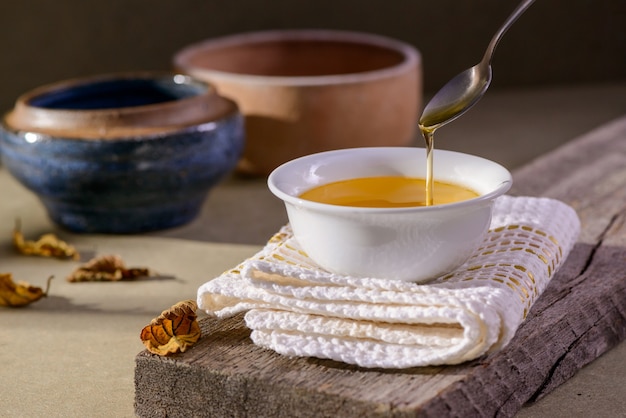 Ghee butter from India in white dinnerware container on wooden table.