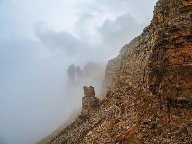 Ghost rocks Awesome scenic mountain landscape with big cracked pointed stones closeup in misty morning Sharp rocks background