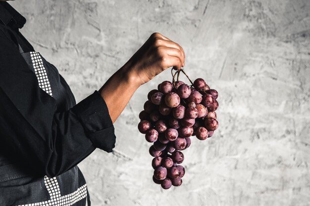 Giant grapes on hand on a gray background