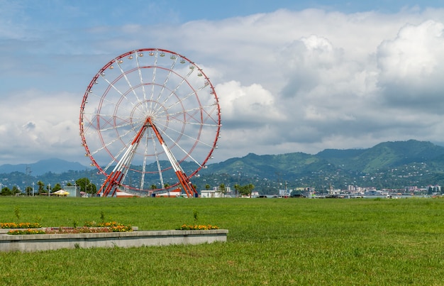 Ruota panoramica gigante rossa e bianca con le montagne