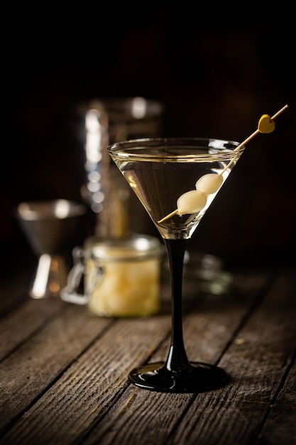 Gibson-alcoholcocktail met martini en uien in martini-glas versierde cocktail op donkere achtergrond