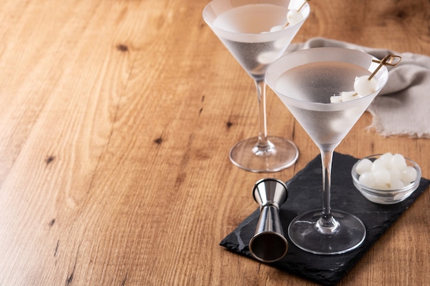 Gibson martini cocktail with onions on wooden