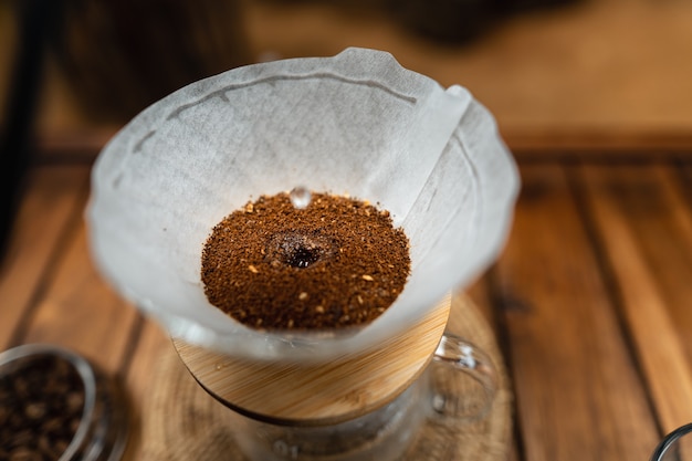 Giet heet water in koffie., druppel koffie thuis op een houten tafel