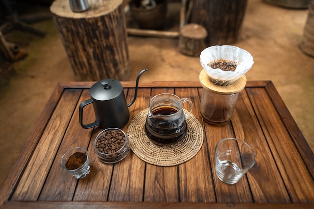 Giet heet water in koffie., druppel koffie thuis op een houten tafel