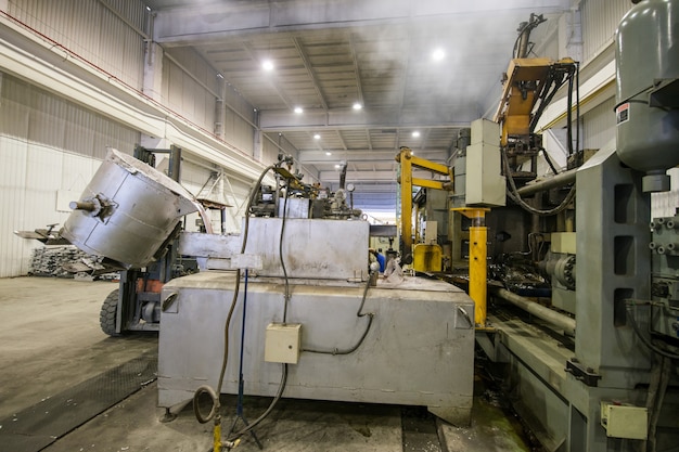 Giet het aluminiummetaal van de pollepel naar de laadmachine in een grote container