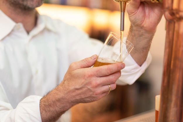 Gietend bier voor cliënt. Barman gieten bier terwijl je aan de bar.