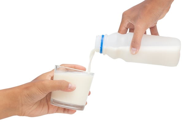 Gietende melk in glas dat op witte achtergrond wordt geïsoleerd - het knippen wegen