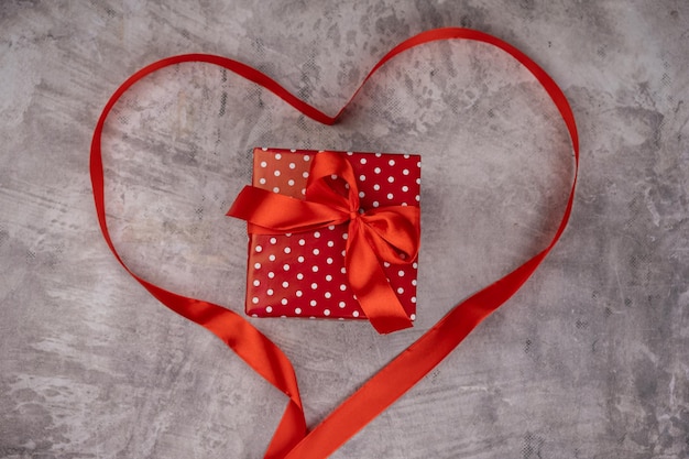 사진 선물 및 심장 모양의 회색 배경에 빨간 리본