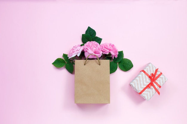 Gift bag with bouquet of pink roses and gift box