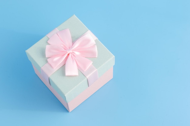 Gift in a beautiful package box with gifts attributes festive mood gift on a blue background