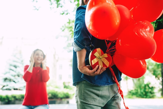 最愛の女性への贈り物。誕生日、聖バレンタインの日とデート。恋をしているカップル。ハンサムな男は彼の美しいかわいいガールフレンドに驚きます