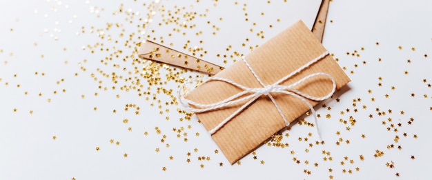 Gift and blank note with envelope, gold glitter stars on white background