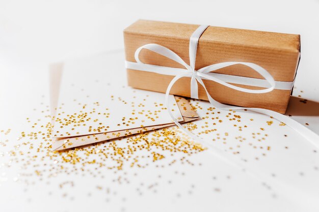 Gift and blank note with envelope, gold glitter stars on white