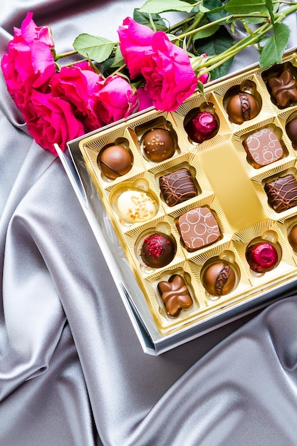 Gift box of assorted gourmet chocolate truffles on silver silk.