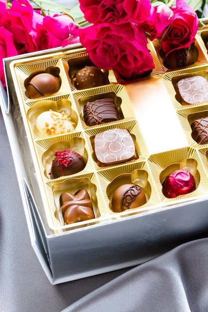 Gift box of assorted gourmet chocolate truffles on silver silk.