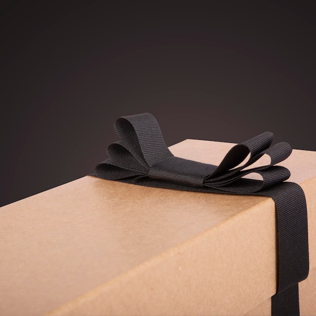 Gift box and a black ribbon on a black background