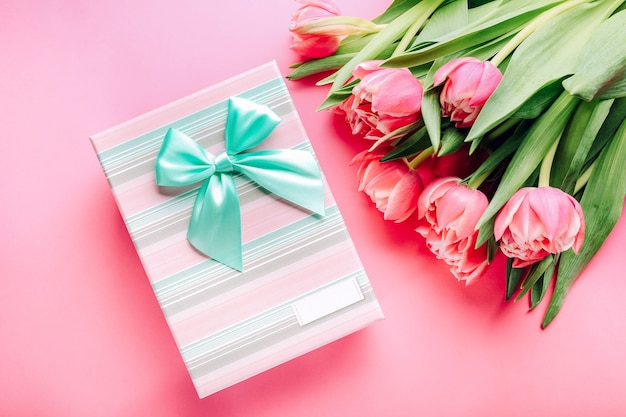 Gift box and bouquet of beautiful tulips on pink