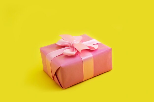 Gift box bow pink on yellow background Festive decoration design