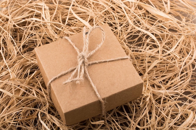 Gift box of brown color on a straw background