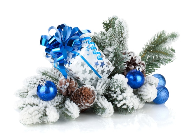Confezione regalo e decorazioni natalizie su abete innevato. isolato su sfondo bianco
