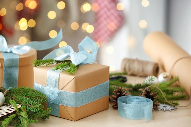 Подарочная коробка и рождественские украшения на столе против размытых огней