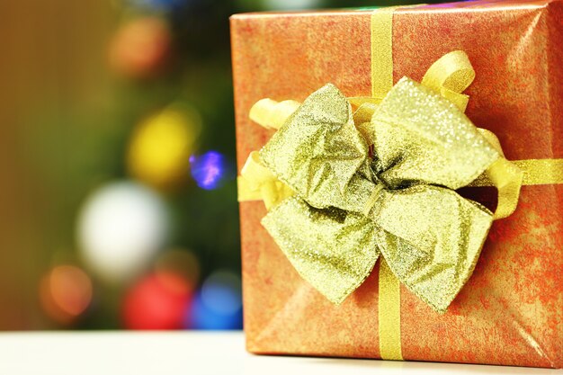 Gift box on Christmas tree lights surface