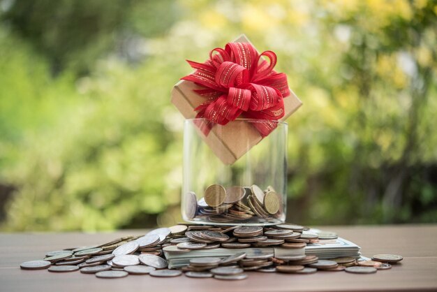 Foto scatola regalo su dollari nel barattolo di vetro