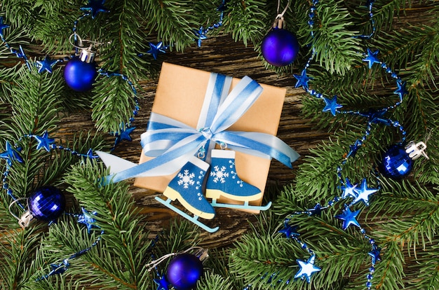 Gift box and fir branches with decoration in blue color.