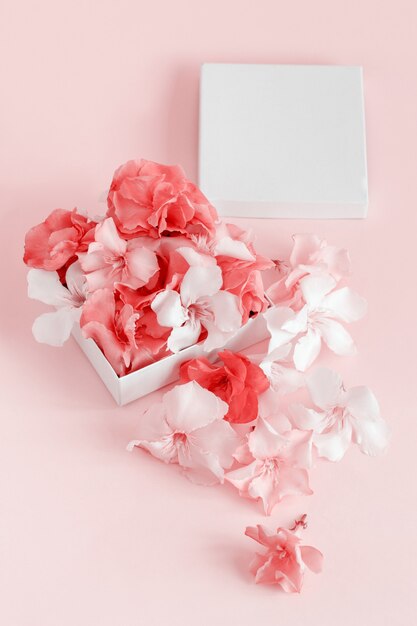 Gift box full of flowers  over a pink background  close up