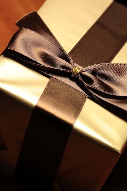 Photo gift box of golden color with brown ribbon