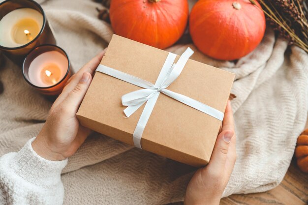 Photo gift box in hands in autumn decor