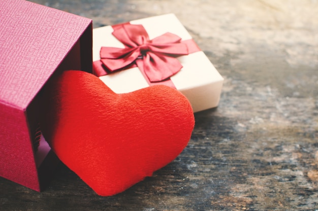 Gift box and heart on brown wood