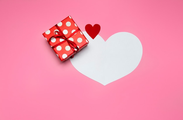 Gift box and heart on a pink background